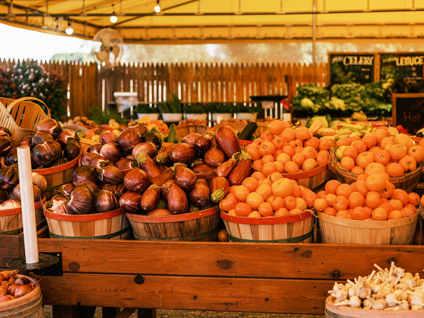 Fresh produce in wooden baskets at a farmer's market.
